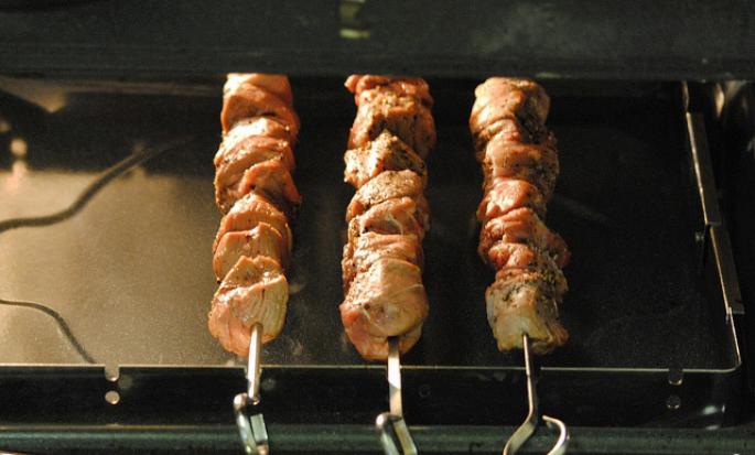 Shish kebab σε ένα μαξιλάρι κρεμμυδιού στο φούρνο
